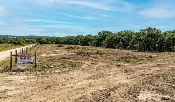 Cleared Texas land parcel with open soil, tree line backdrop, rural setting, bright daylight, ready for sale listing. -Sell My Land Fast Texas. -1